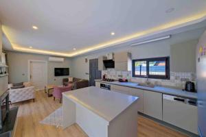 a large kitchen and living room with a counter top at Kıryaman Villa 