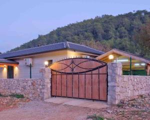 a house with a gate with a stone wall at Kıryaman Villa 