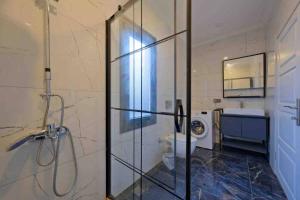 a bathroom with a shower and a toilet and a sink at Kıryaman Villa 
