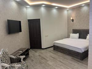 a bedroom with a bed and a tv and a chair at Street51 in Yerevan