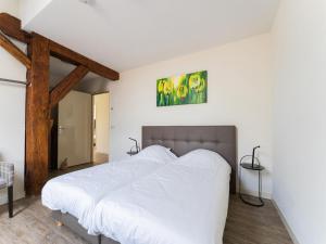 1 dormitorio con 1 cama grande con sábanas blancas en Spacious holiday home in Montfoort with private terrace, en Montfoort