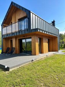 dom z tarasem z dwoma krzesłami w obiekcie Wood Lake Rożnów w mieście Rożnów