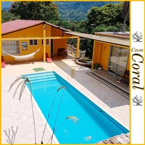 una casa con una piscina azul frente a ella en CASA CORAL, en La Mesa