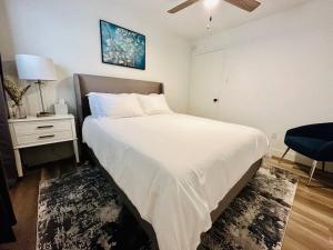 um quarto com uma grande cama branca e uma cadeira em StarryNight @ Museum Park em Houston