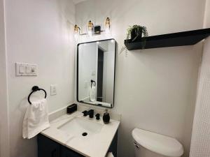 ein weißes Badezimmer mit einem Waschbecken und einem Spiegel in der Unterkunft StarryNight @ Museum Park in Houston