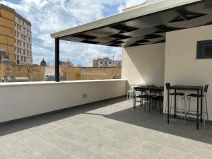 a patio with tables and chairs on a roof at La Corte 25 in Marsala