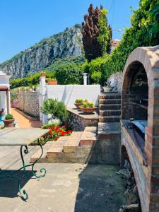 a garden with a bench and stairs with a mountain at B&B L'Agapanto in Capri