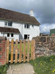 a wooden fence in front of a house at Little Stone Farm Cottage in South Molton