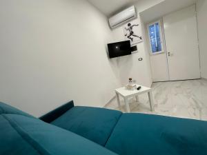 ein Wohnzimmer mit einem blauen Sofa und einem Tisch in der Unterkunft La vie est belle in Neapel