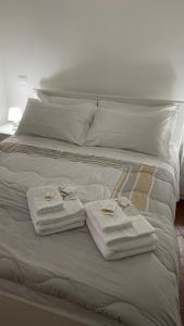 Una cama con toallas y anillos encima. en Casa Valentina 1, en Perugia