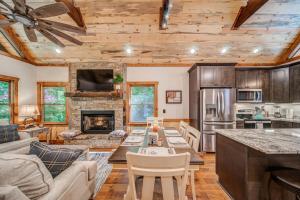a kitchen and living room with a table and a fireplace at Brand New Build Luxury Mountain Chalet with Hot tub, pool, Game Room, Premium features in Ellijay