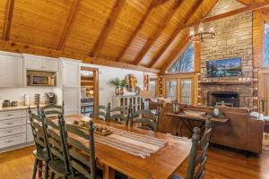 ein Esszimmer und eine Küche mit einem Holztisch und Stühlen in der Unterkunft Peek-a-Boo Lodge in Banner Elk