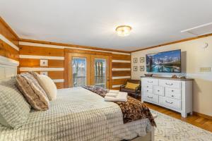 Schlafzimmer mit einem Bett und einer Kommode mit einem TV in der Unterkunft Peek-a-Boo Lodge in Banner Elk