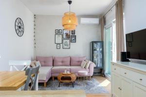a living room with a pink couch and a table at Apartment Ivy in Split