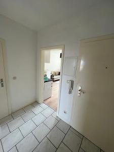 una stanza vuota con una porta e un pavimento piastrellato di Möblierte Wohnung in Duisburg a Duisburg