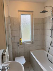 uma casa de banho com uma banheira, um WC e um lavatório. em Möblierte Wohnung in Duisburg em Duisburgo