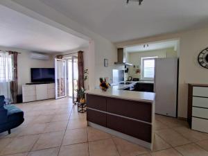 Apartment Teleferica Rabac في راباك: مطبخ وغرفة معيشة مع ثلاجة وأريكة
