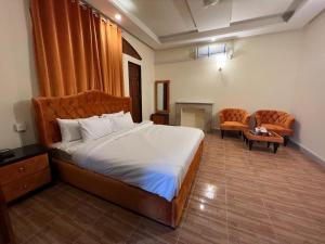 a bedroom with a bed and a living room at Heritage Inn in Islamabad