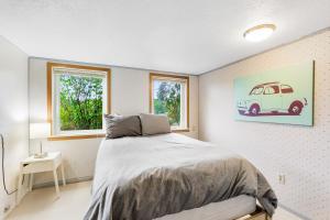 a bedroom with a bed and a picture of a car on the wall at Blanco Style in Poulsbo