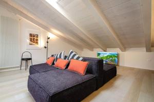 sala de estar con sofá negro y almohadas de color naranja en Asinelli Luxury Apartment, en Bolonia