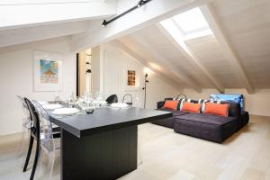 a dining room with a table and a couch at Asinelli Luxury Apartment in Bologna