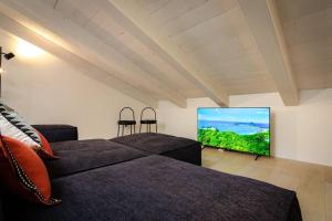 Una sala de estar con dos camas y un televisor de pantalla plana. en Asinelli Luxury Apartment, en Bolonia