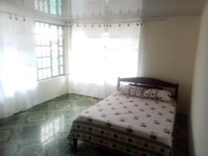 een slaapkamer met een bed voor een raam bij PORTALES DEL LLANO in Villavicencio