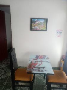 een eettafel met 2 stoelen en een foto aan de muur bij PORTALES DEL LLANO in Villavicencio