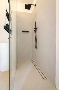 Un baño con ducha con puerta de cristal. en Asinelli Luxury Apartment, en Bolonia 46 fotos más