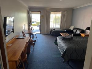 Habitación de hotel con cama y sala de estar. en Asters On James Motor Inn, en Toowoomba