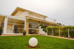 un œuf blanc sur l'herbe devant une maison dans l'établissement Rainone Resort - San Marco di Castellabate, à Castellabate