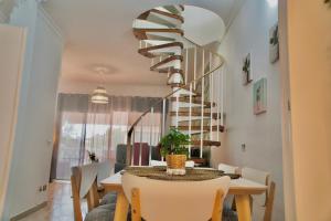 a dining room with a table and a spiral staircase at Heart and Soul Apartment in San Miguel de Abona