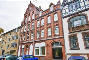 a brick building with cars parked in front of it at Schöne Wohnung für 4 Gäste an der Eilenriede mit kostenlosen Parkplätzen in Hannover