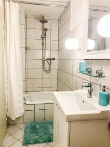 La salle de bains est pourvue d'une baignoire, d'un lavabo et d'une douche. dans l'établissement Schöne Wohnung für 4 Gäste an der Eilenriede mit kostenlosen Parkplätzen, à Hanovre