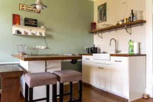 a kitchen with white cabinets and a bar with stools at The Good Place in Kreuzberg Berlin in Berlin