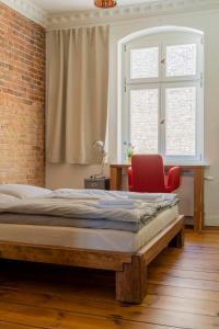ein Schlafzimmer mit einem großen Bett und einem roten Stuhl in der Unterkunft The Good Place in Kreuzberg Berlin in Berlin