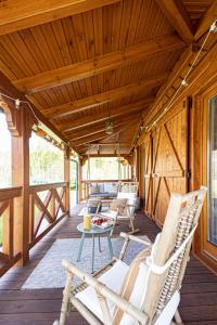 a porch with rocking chairs and a table on a deck at Uroczysko Lubajny in Idzbark