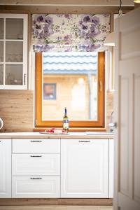 a kitchen with white cabinets and a window at Uroczysko Lubajny in Idzbark +17 photos