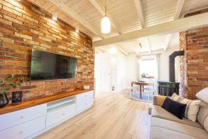 a living room with a brick wall with a flat screen tv at Uroczysko Lubajny in Idzbark