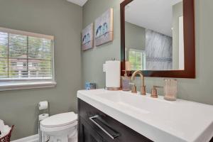 a bathroom with a sink and a toilet and a mirror at The Clark at Midtown Memphis in Memphis