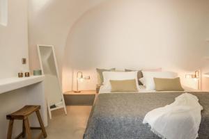 1 dormitorio con 1 cama grande y 1 mesa en Cleo's Dream Villa en Oia