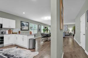 a kitchen with white cabinets and a living room at The Clark at Midtown Memphis in Memphis