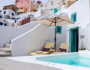 a villa with a swimming pool and an umbrella at Cleo's Dream Villa in Oia