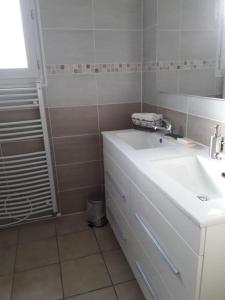 La salle de bains blanche est pourvue d'un lavabo et d'un miroir. dans l'établissement Maison sur les hauteurs de Carcassonne, à Carcassonne