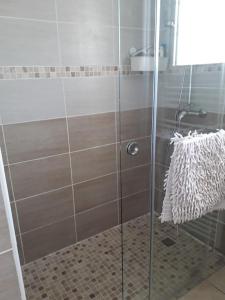 La salle de bains est pourvue d'une douche avec une porte en verre. dans l'établissement Maison sur les hauteurs de Carcassonne, à Carcassonne