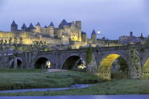 un vieux pont en pierre avec un château en arrière-plan dans l'établissement Maison sur les hauteurs de Carcassonne, à Carcassonne