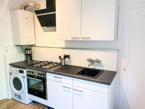 kuchnia z białymi szafkami, kuchenką i zlewem w obiekcie Wohnung für 3 Gäste mit kostenlosen Parkplätzen nah am Maschsee w Hanowerze