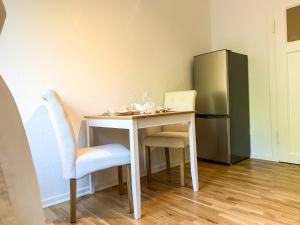 einen kleinen Tisch mit 2 Stühlen und einen Kühlschrank in der Unterkunft Wohnung für 3 Gäste mit kostenlosen Parkplätzen nah am Maschsee in Hannover