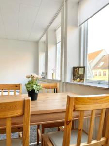 uma sala de jantar com uma mesa de madeira e cadeiras em Scandinavian Apartment Hotel - Tobaksgården - 2 room apartment em Horsens