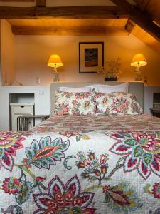 ein Schlafzimmer mit einem großen Bett mit einer farbenfrohen Tagesdecke in der Unterkunft Esparoutis in Saint-Cybranet